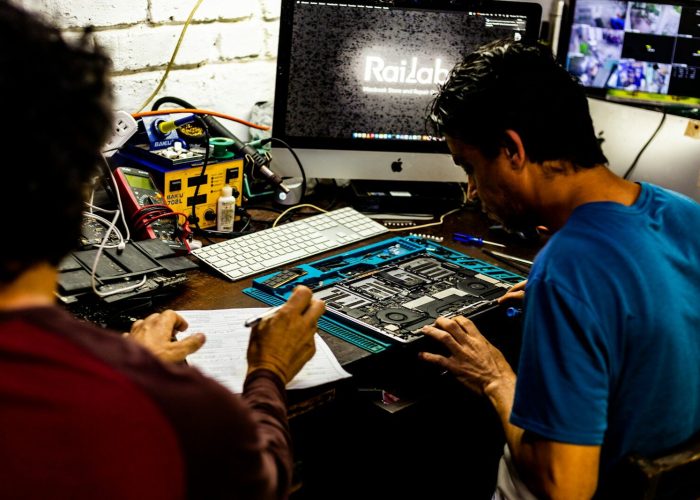 Two men working on a computer motherboard